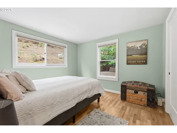 a bedroom with a bed and a window with chair