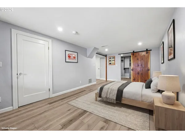 a bedroom with a bed and wooden floor