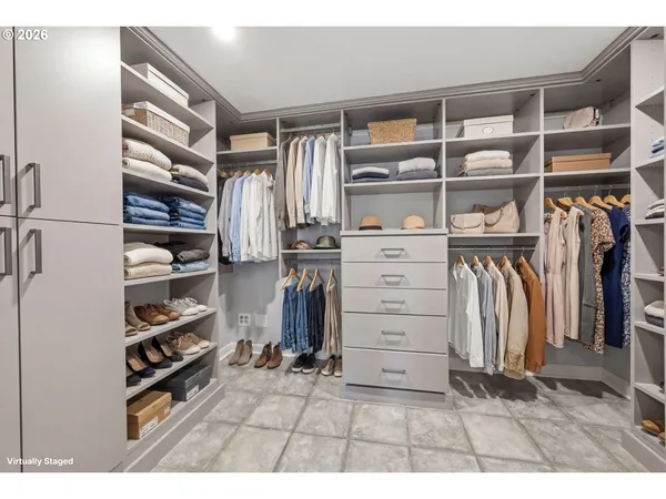a view of walk in closet with clothes and shoes