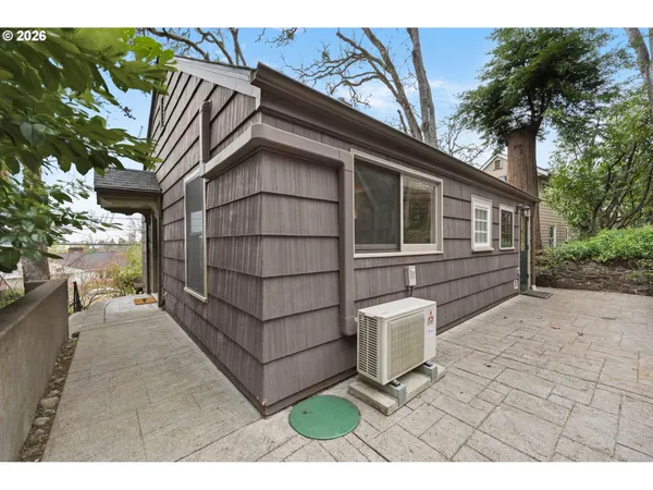 a view of a small house with roof and wooden fence