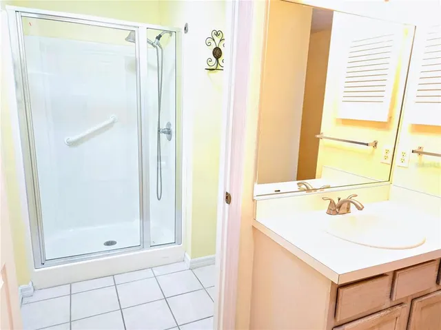 a bathroom with a shower sink and a mirror