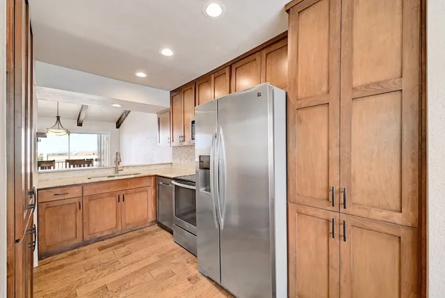 a kitchen with stainless steel appliances granite countertop a refrigerator and a sink