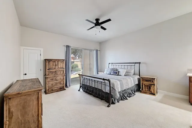 a bed room with a bed and a ceiling fan
