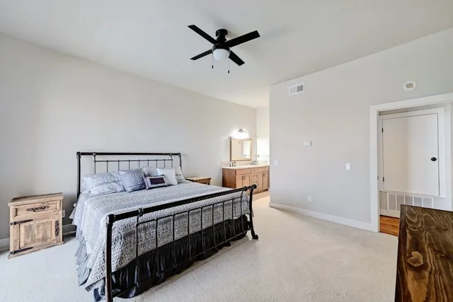 a bedroom with a bed a window and a chandelier