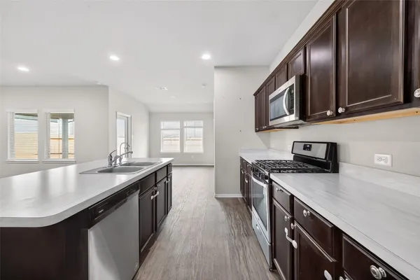 a kitchen with stainless steel appliances granite countertop a sink a stove and a microwave
