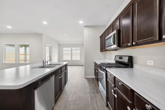 a kitchen with stainless steel appliances granite countertop a sink a stove and a microwave