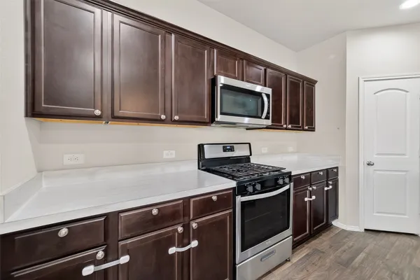 a kitchen with stainless steel appliances a stove a microwave and cabinets