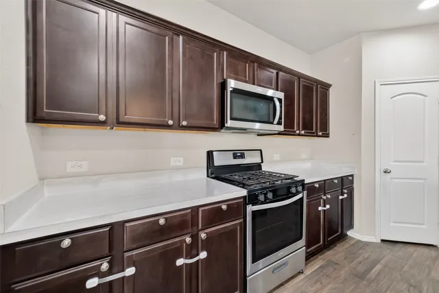 a kitchen with stainless steel appliances a stove a microwave and cabinets