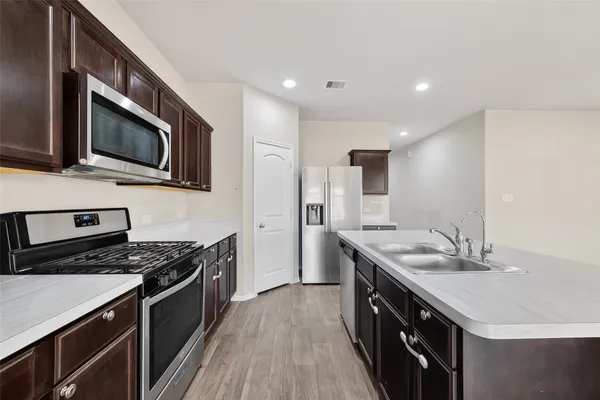 a kitchen with stainless steel appliances a stove microwave and cabinets