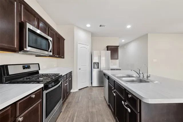 a kitchen with stainless steel appliances a stove microwave and cabinets