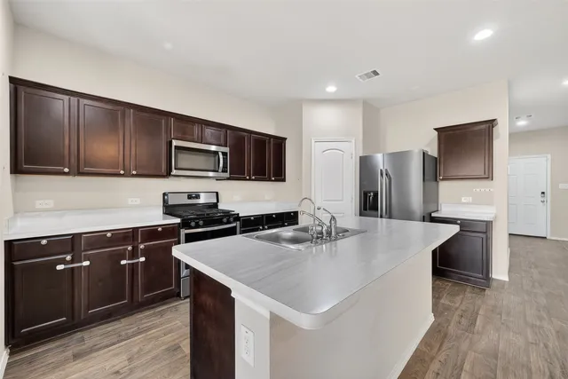 a kitchen with a stove a sink and a refrigerator