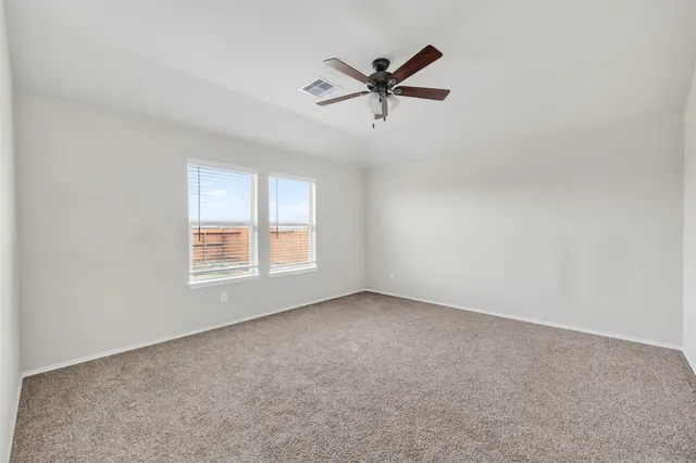 an empty room with closet and ceiling fan