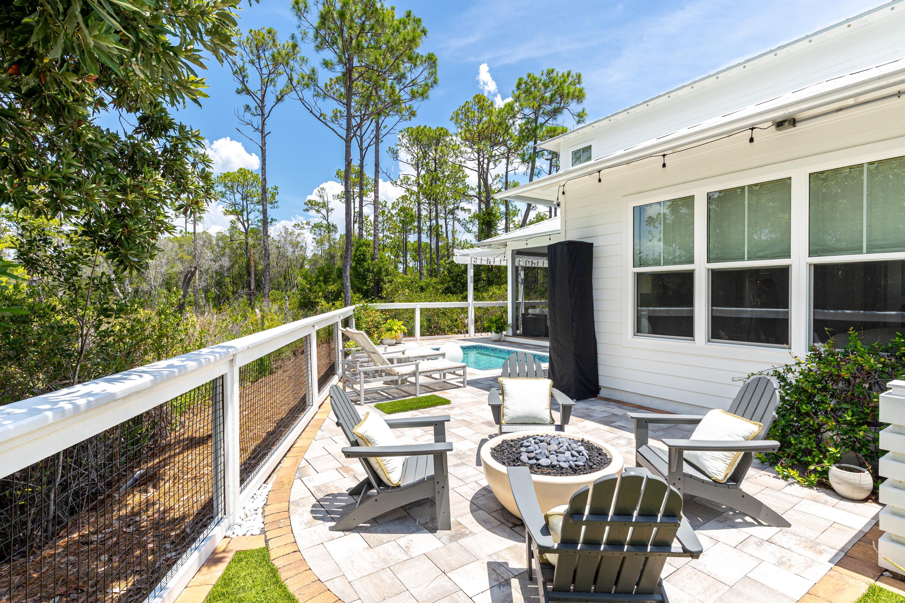 235 Prairie Pass Santa Rosa Beach, FL 32459 - Photo 41 of 80 a view of a patio with couches table and chairs and potted plants