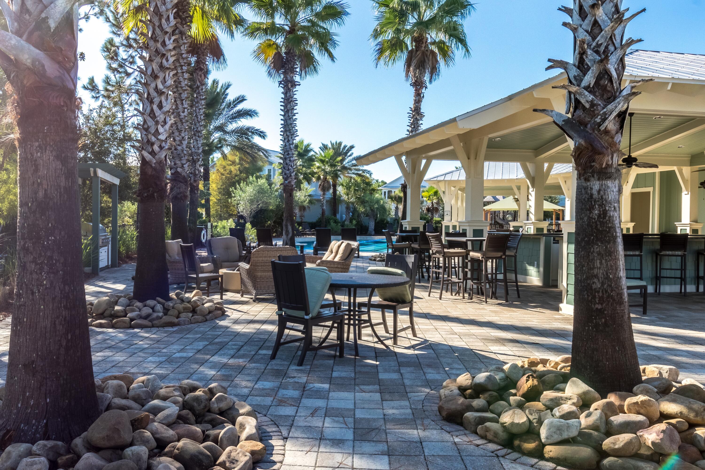 235 Prairie Pass Santa Rosa Beach, FL 32459 - Photo 68 of 80 a view of a patio with table and chairs potted plants and a large tree
