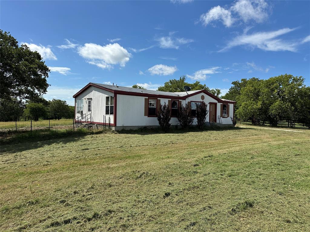 570 Big Salty Lane Springtown, TX 76082 - Photo 14 of 36 White siding residence with a red trim roof and accent shutters