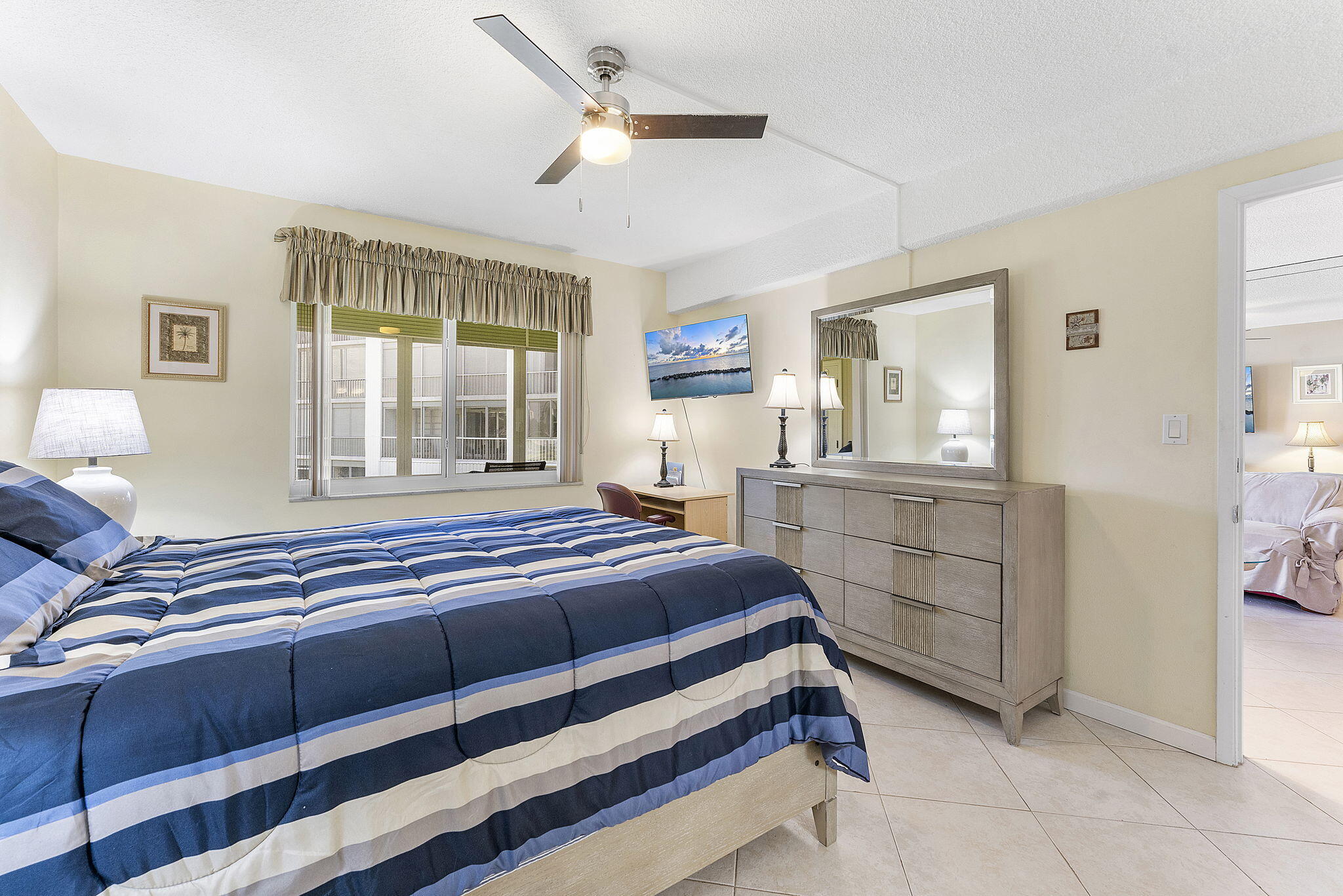 101 Northeast 19th Avenue, Unit 208 Deerfield Beach, FL 33441 - Photo 16 of 38 a bedroom with a bed and a dresser