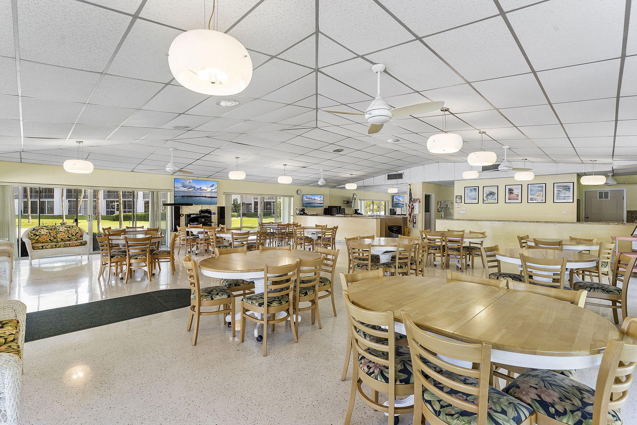 101 Northeast 19th Avenue, Unit 208 Deerfield Beach, FL 33441 - Photo 27 of 38 a room with lots of tables a chandelier and couches