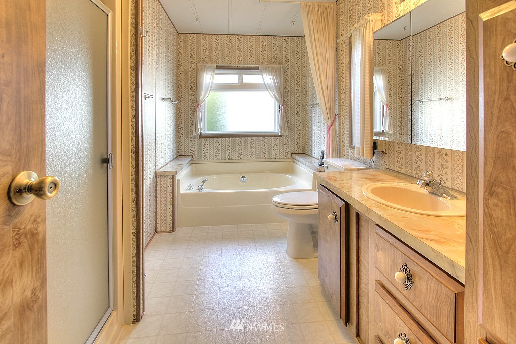 23631 Lake Drive East Bothell, WA 98021 - Photo 14 of 25 a bathroom with a granite countertop sink mirror bathtub and toilet