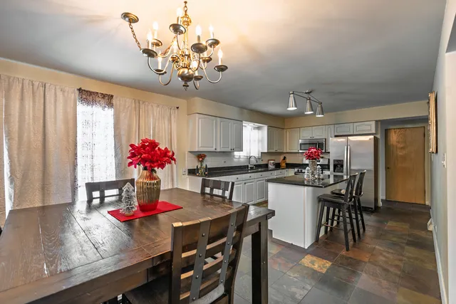 a kitchen with a dining table chairs chandelier and kitchen view