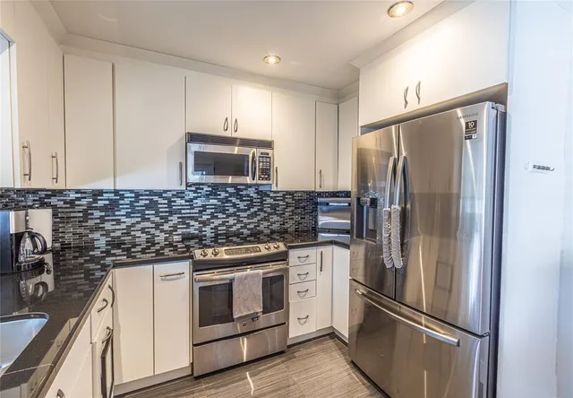 a kitchen with a refrigerator sink and cabinets