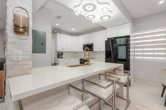 a kitchen with stainless steel appliances a refrigerator and a stove top oven