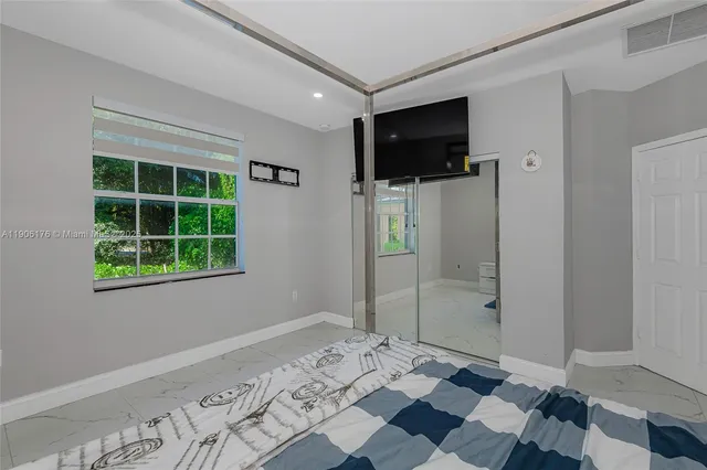 a view of a livingroom with wooden floor and a flat screen tv