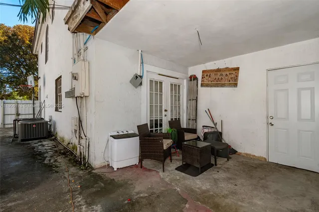 a living room with patio furniture and a wooden floor