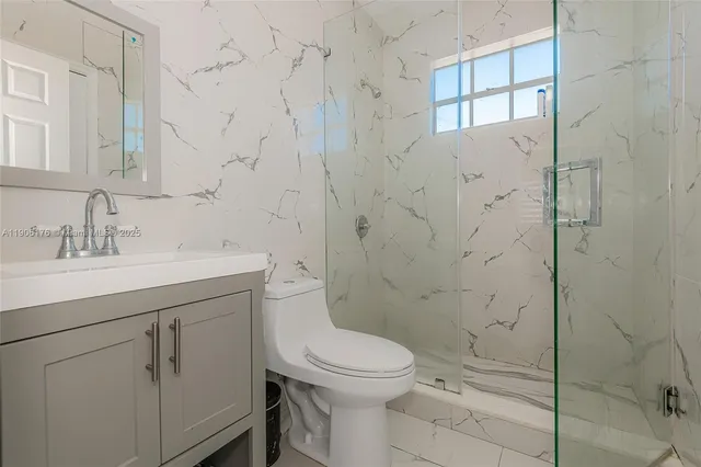 a bathroom with a toilet sink vanity and shower
