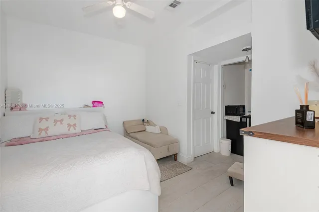 a bedroom with a bed and a potted plant on a dresser