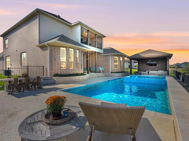 a view of a house with swimming pool and sitting area