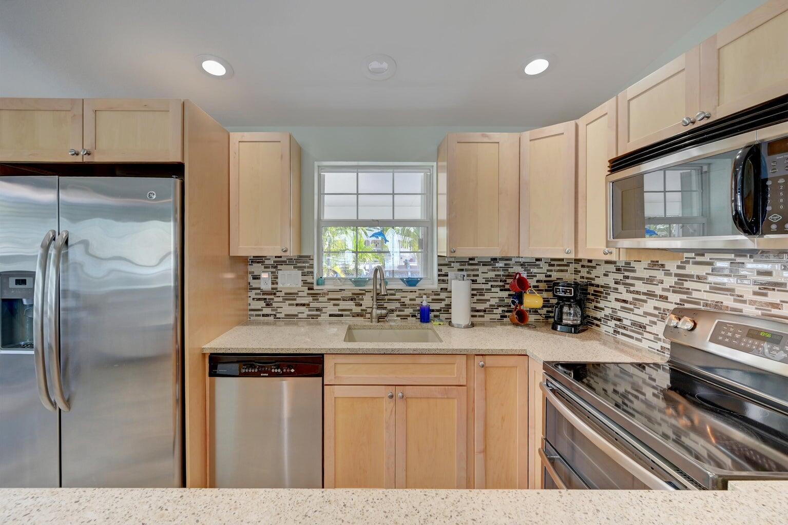239 Lower Matecumbe Road, Unit 239 Key Largo, FL 33037 - Photo 23 of 69 a kitchen with kitchen island granite countertop a sink stove and refrigerator