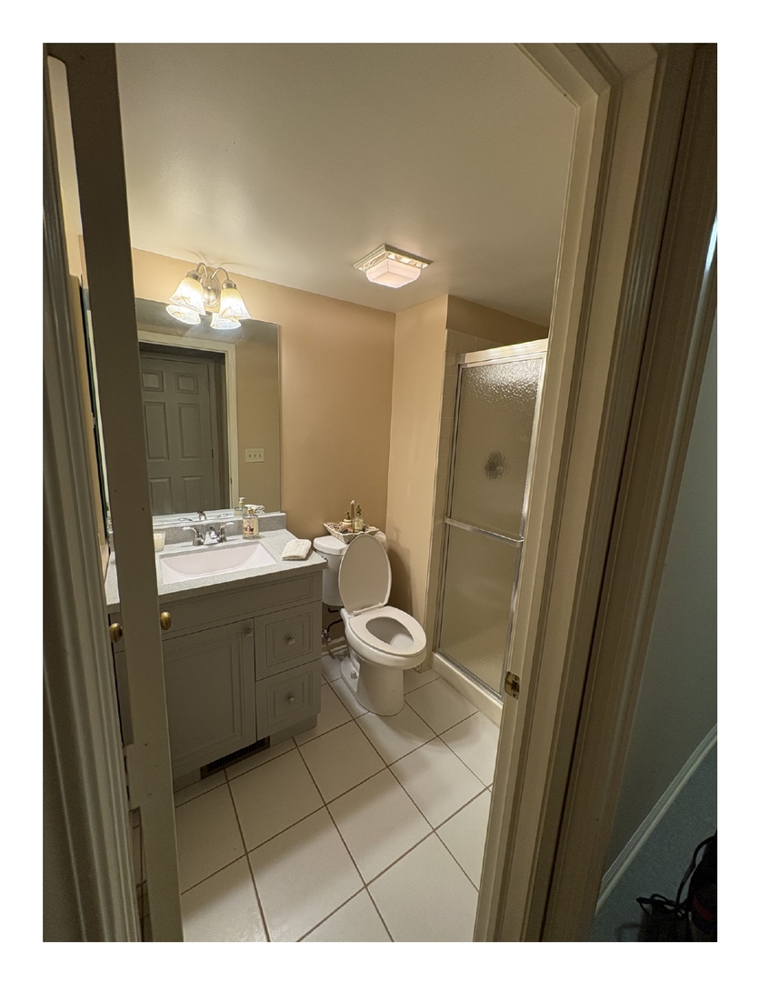 1249 Oak Hill Road, Unit CONDO Lake Barrington, IL 60010 - Photo 6 of 22 a bathroom with a granite countertop sink toilet a mirror and vanity