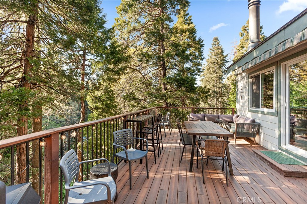 576 Kuffel Canyon Road Lake Arrowhead, CA 92352 - Photo 31 of 61 a view of a deck with table and chairs and wooden floor