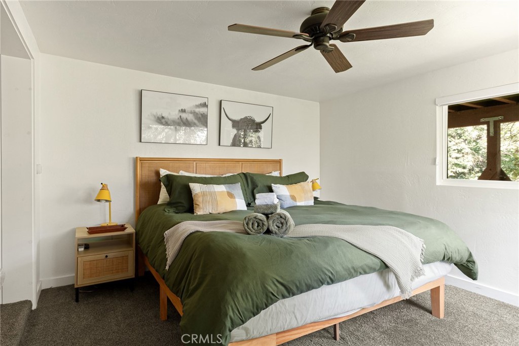 576 Kuffel Canyon Road Lake Arrowhead, CA 92352 - Photo 47 of 61 a bedroom with a bed and a chandelier