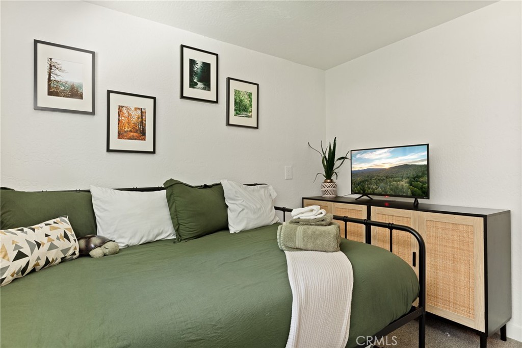 576 Kuffel Canyon Road Lake Arrowhead, CA 92352 - Photo 55 of 61 a living room with a couch and a flat screen tv