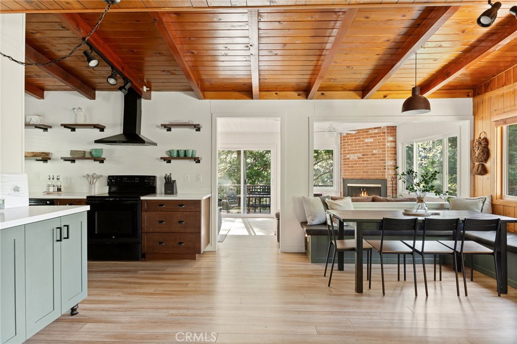 576 Kuffel Canyon Road Lake Arrowhead, CA 92352 - Photo 7 of 61 a kitchen with stainless steel appliances granite countertop a stove a refrigerator a dining table and chairs with wooden floor