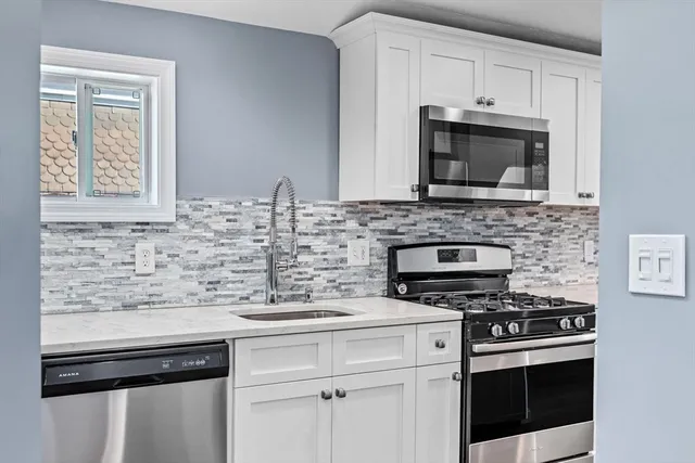 a kitchen with cabinets stainless steel appliances and a sink