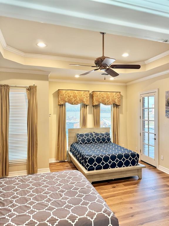 2300 Berend Road Pilot Point, TX 76258 - Photo 14 of 39 Bedroom featuring a raised ceiling, ornamental molding, light wood-type flooring, ceiling fan, and access to exterior