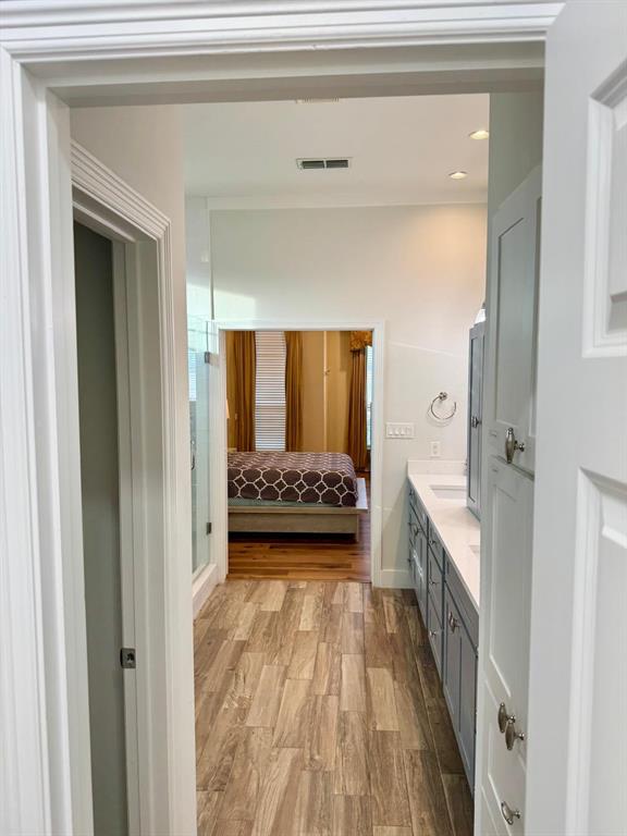2300 Berend Road Pilot Point, TX 76258 - Photo 17 of 39 Ensuite bathroom featuring double vanity, light wood-type flooring, and a shower stall