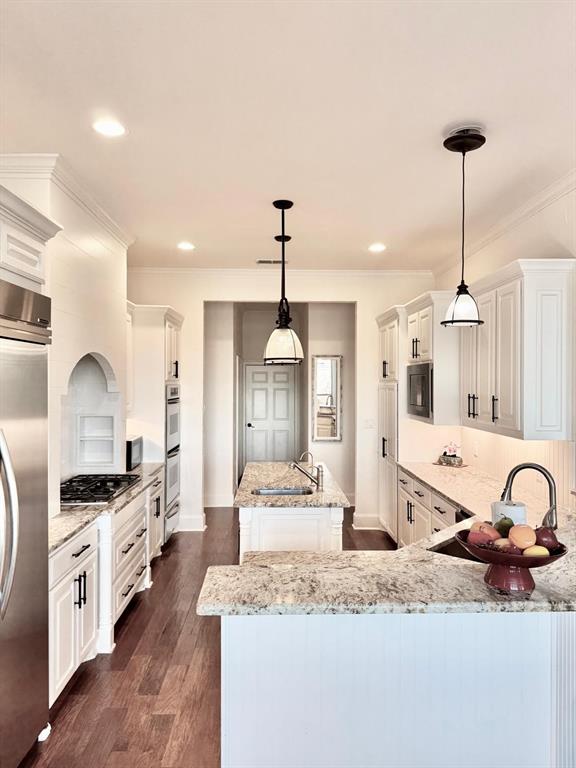 2300 Berend Road Pilot Point, TX 76258 - Photo 18 of 39 Kitchen with white cabinetry, a center island, backsplash, hanging light fixtures, and crown molding