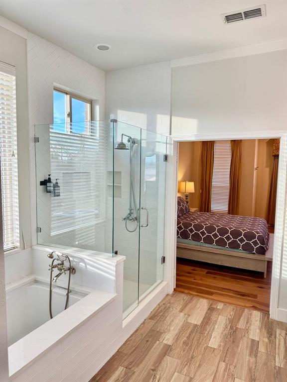 2300 Berend Road Pilot Point, TX 76258 - Photo 27 of 39 Ensuite bathroom with a bath, a stall shower, and light wood-style floors