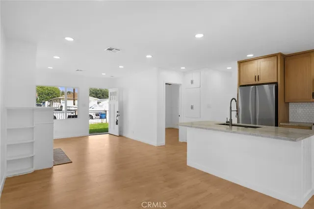 a view of a kitchen with kitchen island a counter top space wooden floor and appliances
