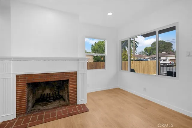 an empty room with windows and fireplace