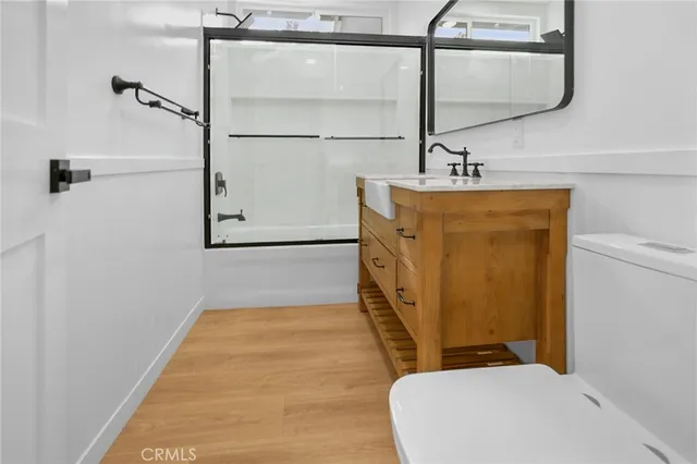 a bathroom with a sink and mirror with bathtub