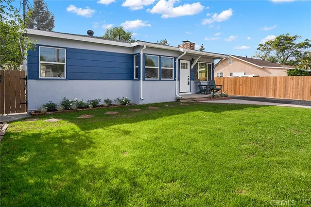 a view of a house with backyard and sitting area