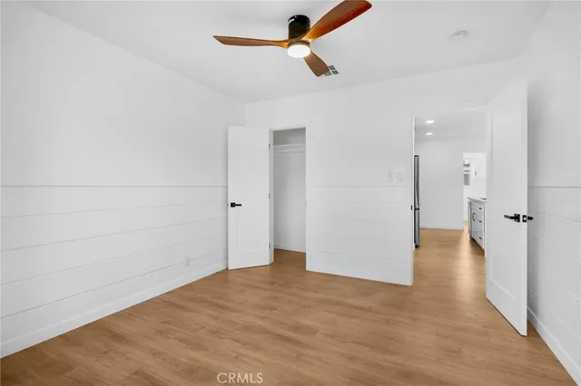 wooden floor in an empty room with a ceiling fan