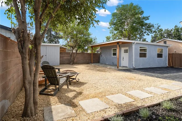 a view of a house with backyard and a tree
