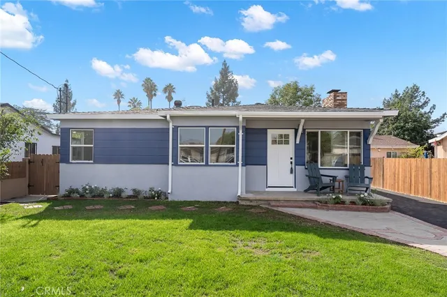 a front view of a house with a garden and yard