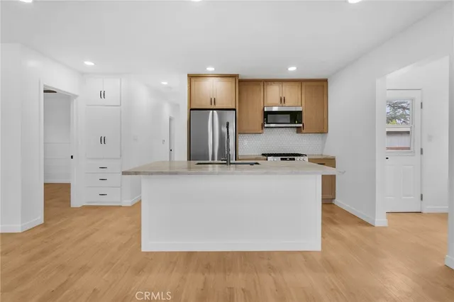 a living room with stainless steel appliances kitchen island wooden floor and view living room