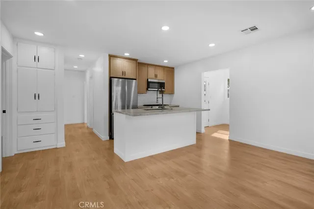 a view of a kitchen cabinets and a refrigerator